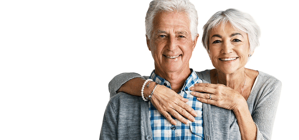 Joyful older couple hugging and smiling.